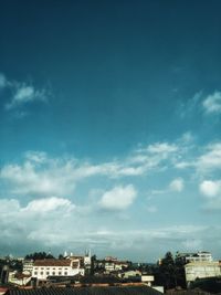 Beautiful urban skyline with historic architecture under a bright blue sky with clouds.